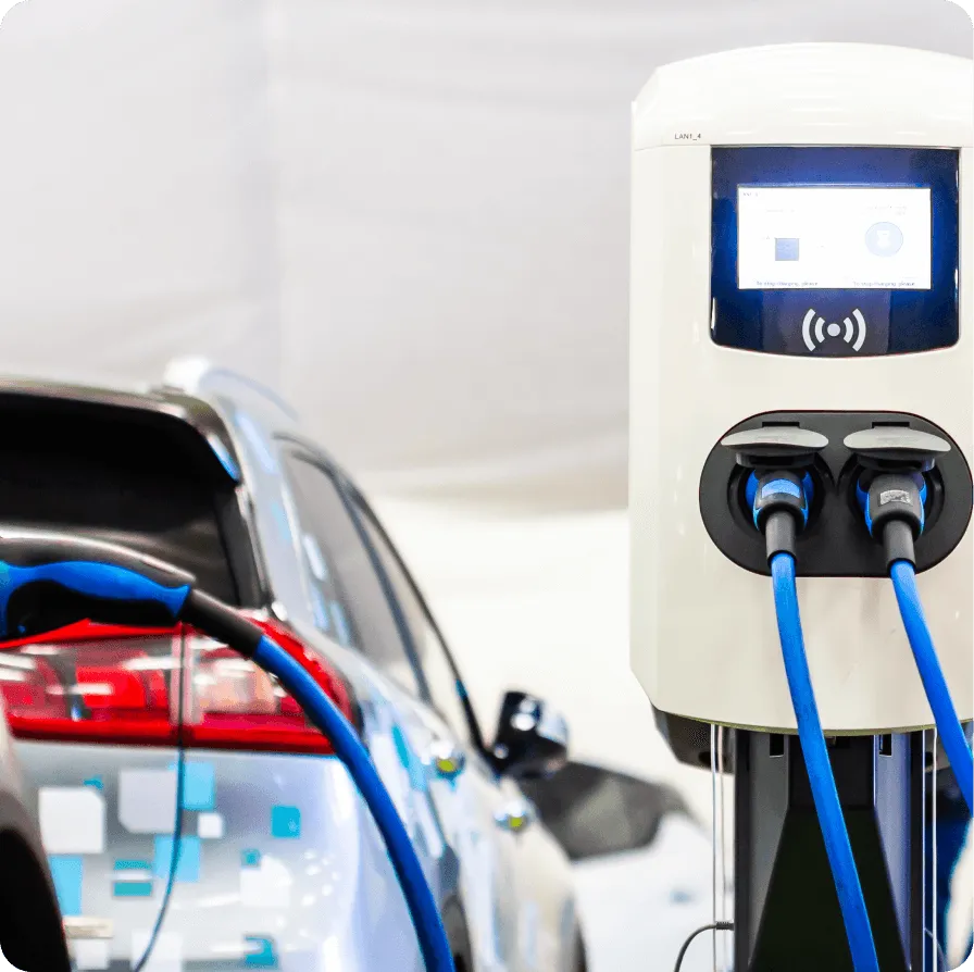 An electric car charging at a charging station.